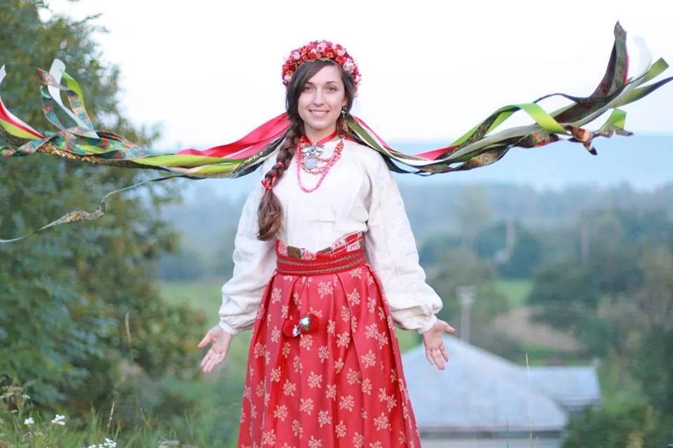 A woman wearing a flower-crown vinok with long ribbons flowing in the wind